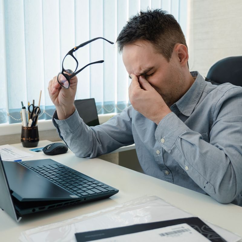 Headache, pain and business man at desk for fatigue, stress or project deadline in office.